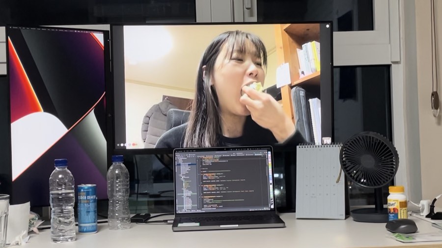 책상 위 모니터에 영상통화로 연결된 유선이 무언가를 먹고 있다